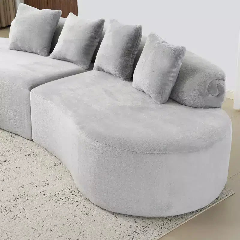 Modern and simple curved flannelette sofa. Creative multi-seater for the living room, with a combination of pillows.